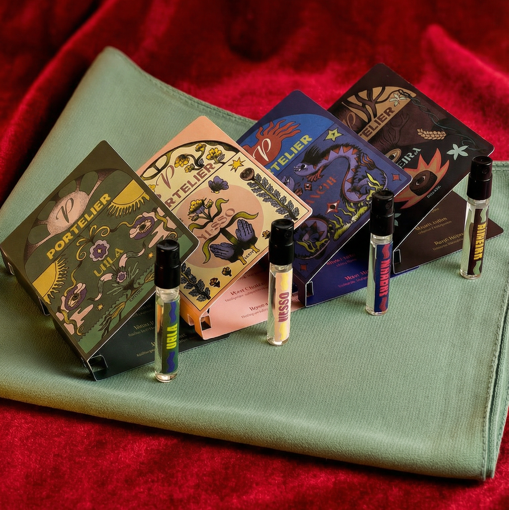 Set of small cosmetic boxes with corresponding vials on a green surface against a red fabric background